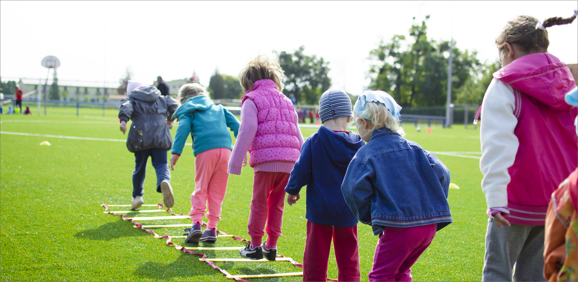 Image of children playing hopscotch outside on a field at school